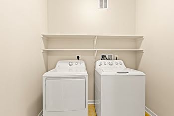 a white washer and dryer in a room with white walls and white appliances